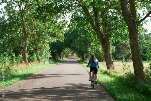 Wallpaper Mural Young Woman Explores the Countryside. Scenic Cycling. Back View of a Carefree Woman on a Bicycle Torontodigital.ca