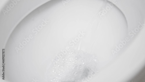 Flush toilet. Water flushes the toilet. The flow of water is clearly visible. Slow motion