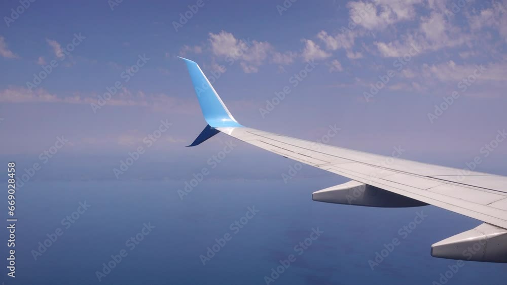 Airplane flight. Wing of an airplane flying above the clouds. View from the window of the plane Airplane flight. Wing of an airplane flying above the clouds. View from the window of the plane