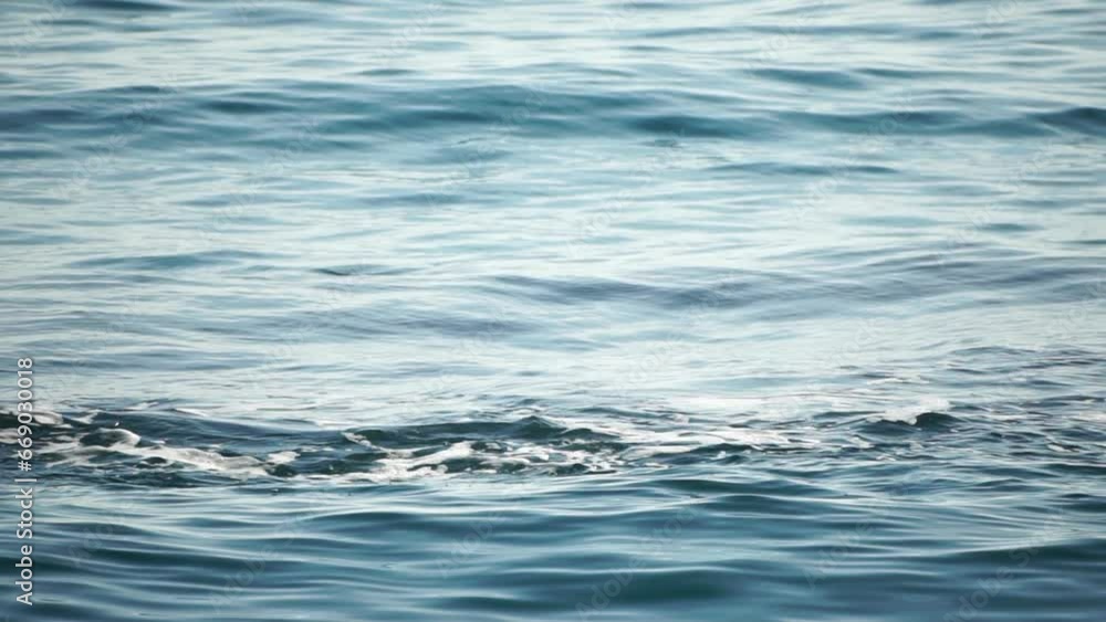 Sea water surface. Low angle view over clear azure sea water. Sun glare. Abstract nautical summer ocean nature. Holiday, vacation and travel concept. Nobody. Slow motion. Weather and climate change Sea water surface. Low angle view over clear azure sea water. Sun glare. Abstract nautical summer ocean nature. Holiday, vacation and travel concept. Nobody. Slow motion. Weather and climate change