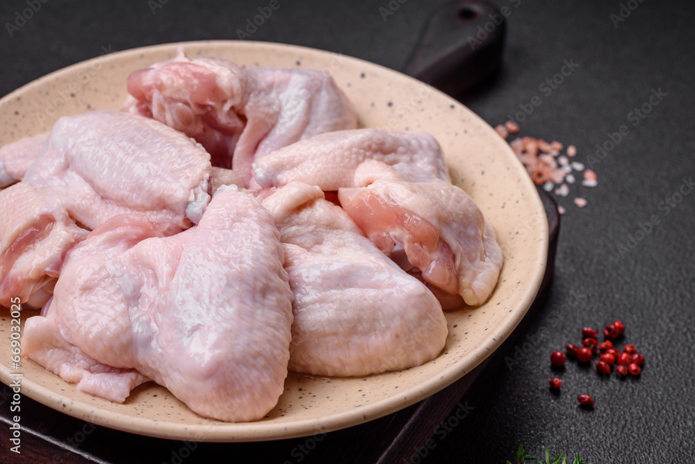 Fresh raw chicken wings with salt and spices prepared for baking