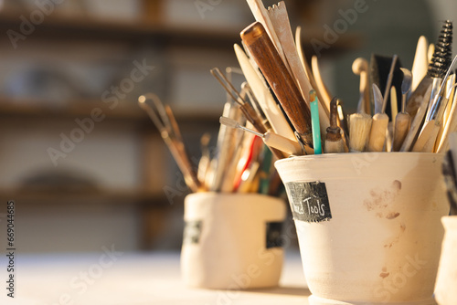 Close up of pottery tools in clay cups in pottery studio