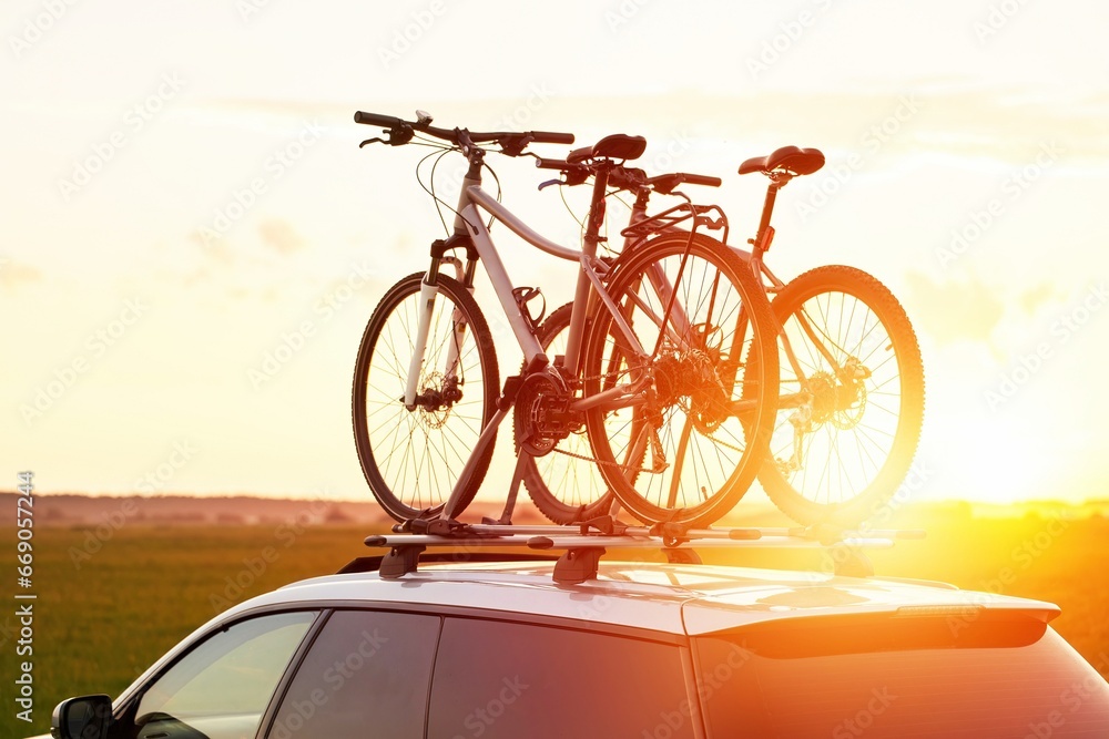 Fototapeta premium two bicycles mounted on the roof of the car. Car Transporting Sports Equipment.