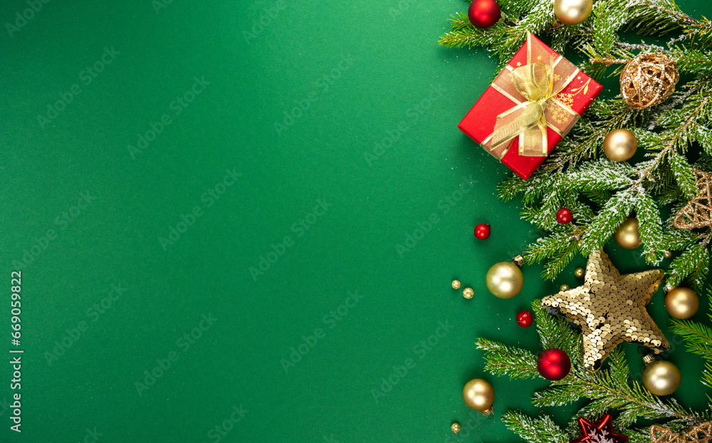 Beautiful green Christmas background with a border of fir branches, golden Christmas toys, stars and gifts. New Year's decoration for congratulations.