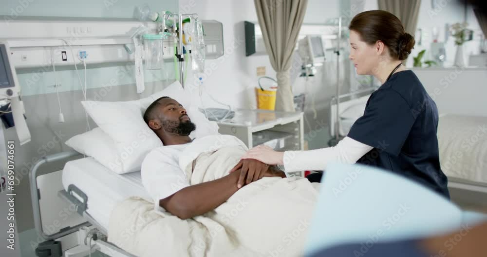 Diverse female doctor and male patient talking in hospital room, slow motion Diverse female doctor and male patient talking in hospital room, slow motion
