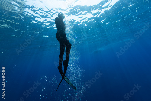 Freediver Swimming in Deep Sea With Sunrays. Young Man DIver Eploring Sea Life. © Lukas Gojda