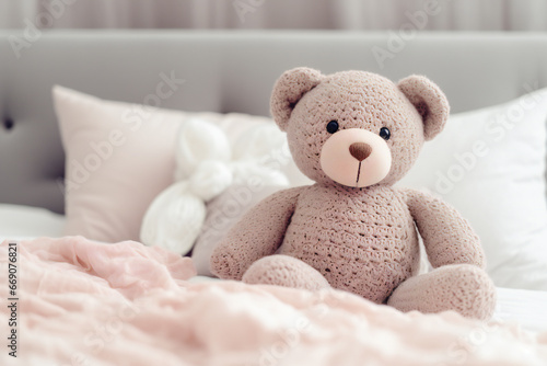 A cute knitted bear on a bed in bedroom