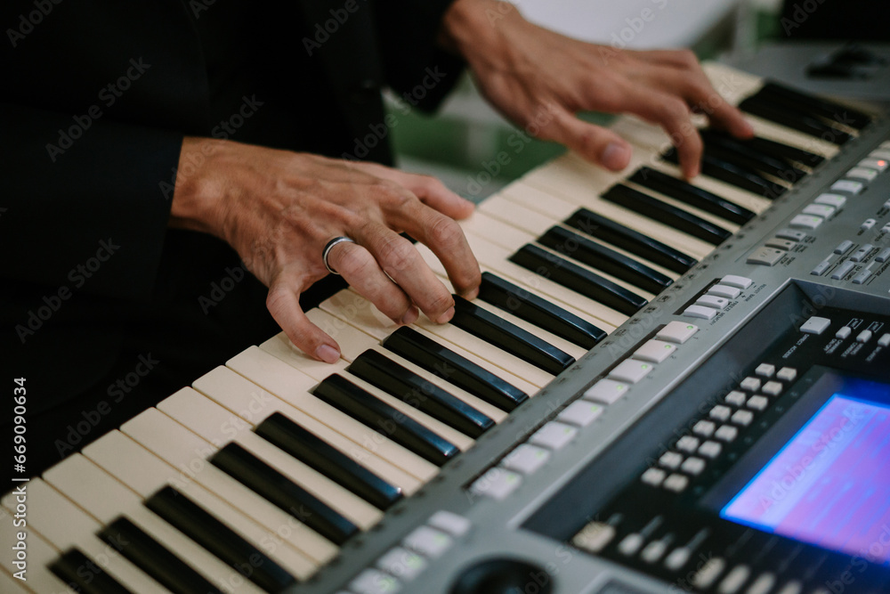 Fototapeta premium a person playing a keyboard sings his favorite song