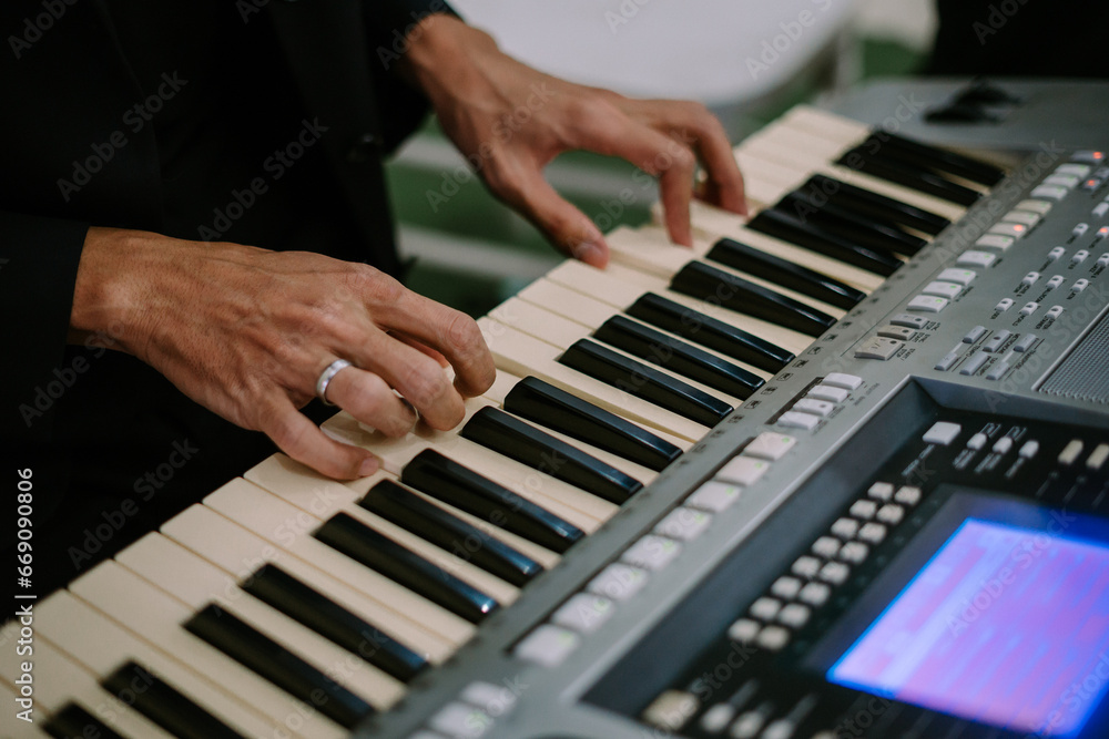 Fototapeta premium a person playing a keyboard sings his favorite song