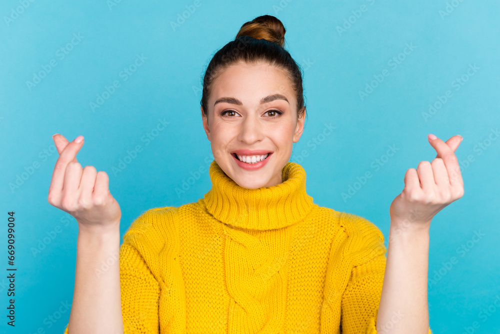 Photo portrait of cute girl snapping fingers showing hearts with fingers isolated on vivid blue colored background Photo portrait of cute girl snapping fingers showing hearts with fingers isolated on vivid blue colored background