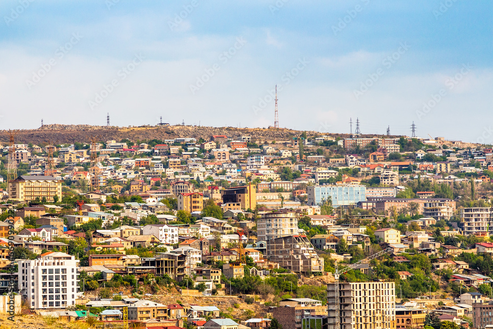 urban houses in Yerevan city illuminated by setting sun, view from Cascade staircases in autumn sunset