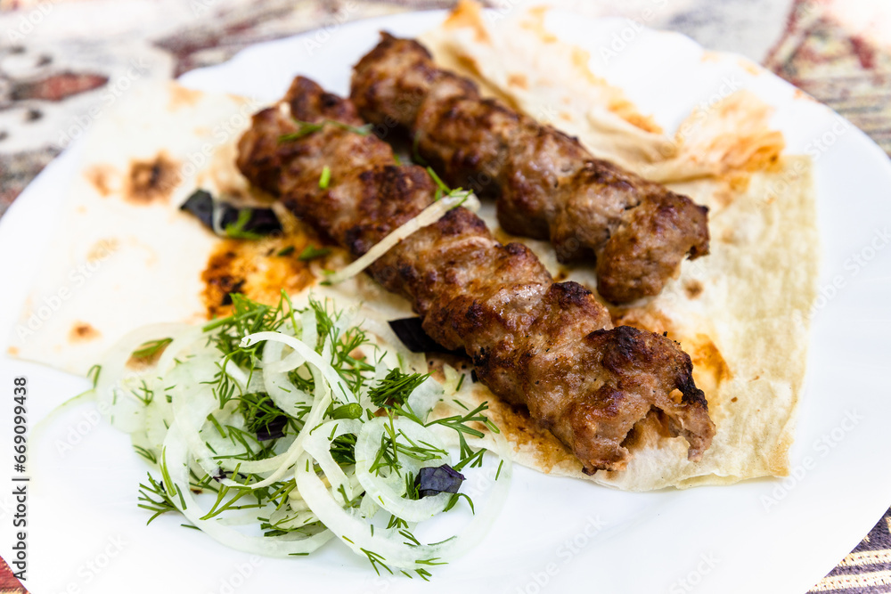 portion of kebabs on plate close up in Armenian village outdoor restaurant