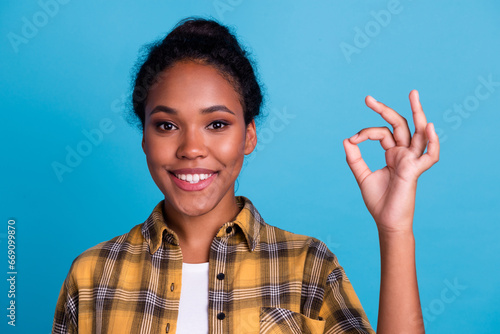 Smiling confident woman assure and guarantee all good, showing okay sign, have situation under control, like and praise promo offer, blue background photo