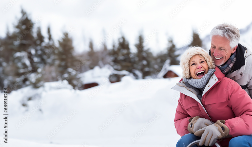 Senior couple looking happy outside in the snow, maybe out sledding or going for a walk. Concept of winter and mature happiness. Shallow field of view with copy space. Senior couple looking happy outside in the snow, maybe out sledding or going for a walk. Concept of winter and mature happiness. Shallow field of view with copy space.