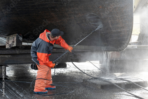 Foto cleaning a ship in the dry dock, cleaning the hull with a high-pressure blaster