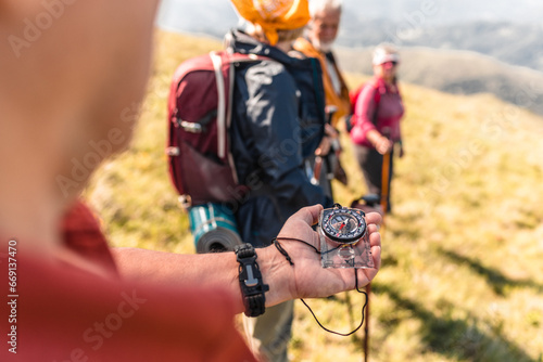 Guided by a compass, hikers prepare for their next adventure photo