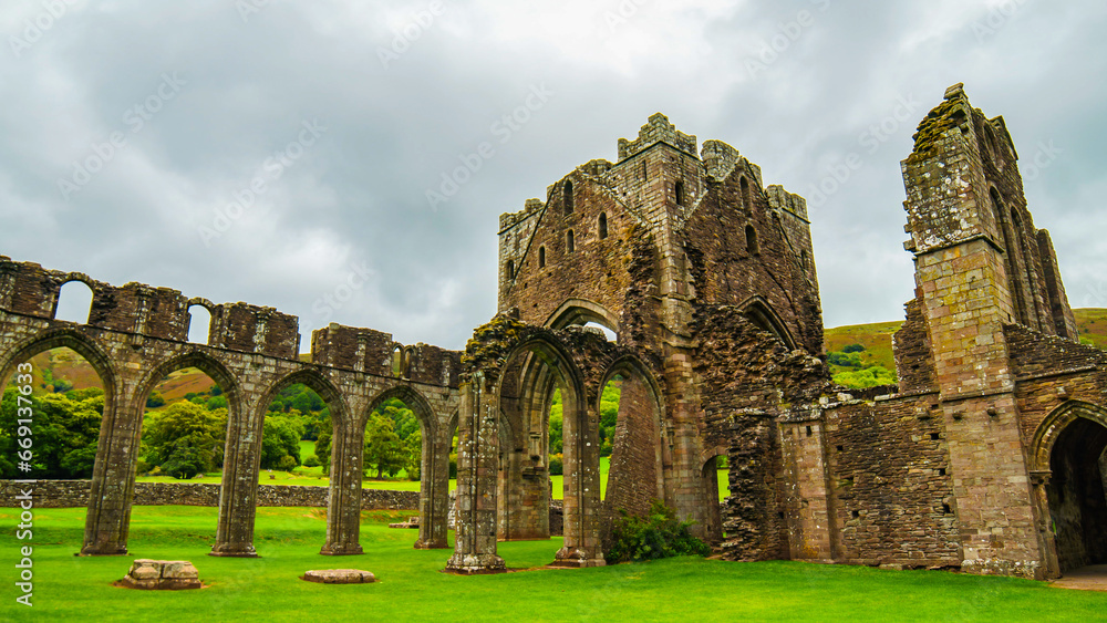Ruins of a medieval castle. Landmarks of Wales travel concept. View of ancient ruins of the castle/church in Brecon Beacons National Park, United Kingdom. Popular tourist attraction. 