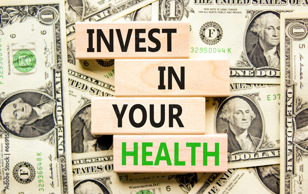 Invest in your health symbol. Concept word Invest in your health on beautiful wooden block. Dollar bills. Beautiful background from dollar bills. Invest in your health concept. Copy space.