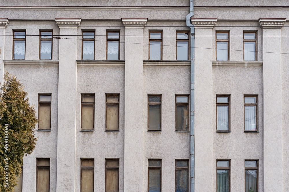 Lots of tall rectangular windows. Old wooden. Three floors. Gray wall. Lots of tall rectangular windows. Old wooden. Three floors. Gray wall.