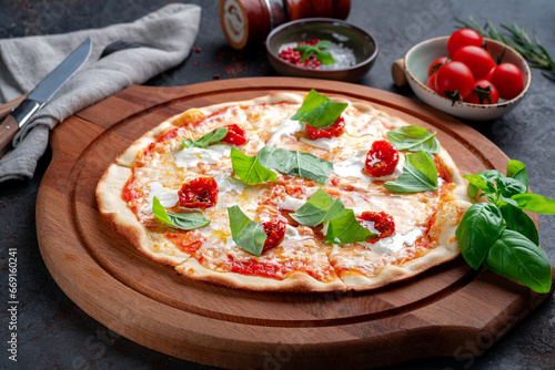 Pizza with strachatella, dried tomatoes and fresh basil. Italian pizza with Stracciatella cheese