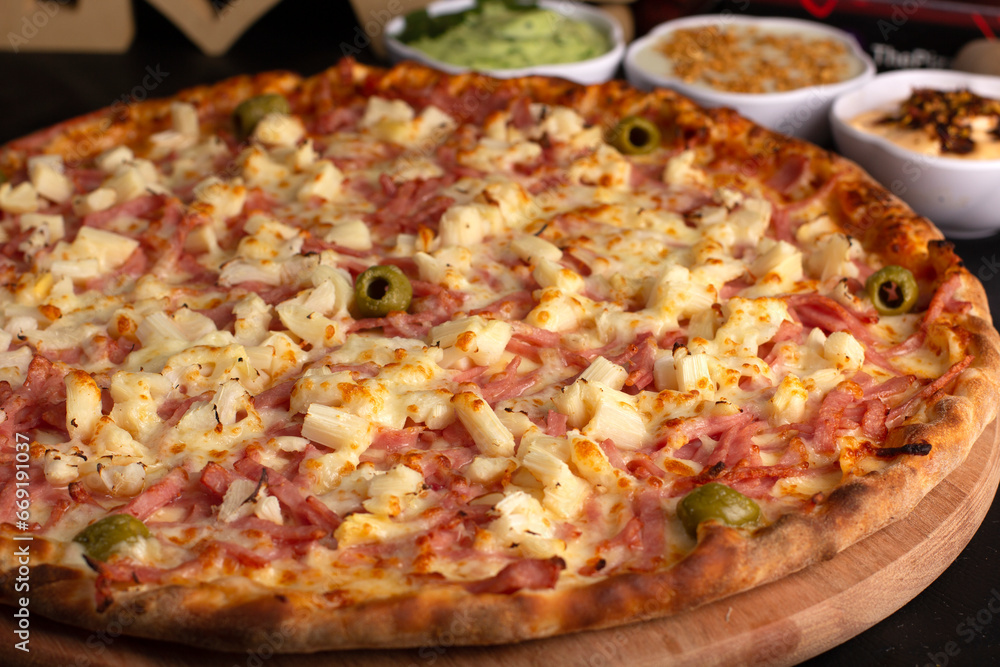 Pizza on a black background with kitchen utensils and ingredients around it, in a studio shot with a black background Pizza on a black background with kitchen utensils and ingredients around it, in a studio shot with a black background