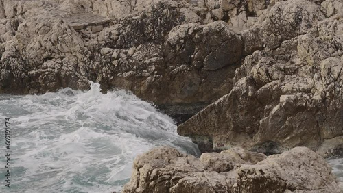 Slow motion sea waves crushing over rocks with soft light photo