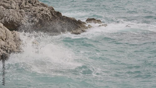 Slow motion sea waves crushing over rocks with soft light photo