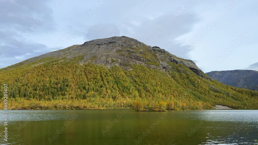 Golden autumn in the Arctic mountains beyond the Arctic Circle. View of a beautiful lake and yellow birches. Mountain peaks in the background. Autumn in the mountains of Khibiny. 4K Golden autumn in the Arctic mountains beyond the Arctic Circle. View of a beautiful lake and yellow birches. Mountain peaks in the background. Autumn in the mountains of Khibiny. 4K