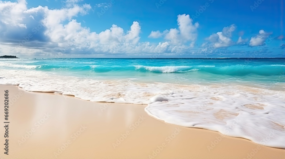 Beautiful natural tropical summer beach background with golden sand, turquoise ocean, and blue sky with white clouds
