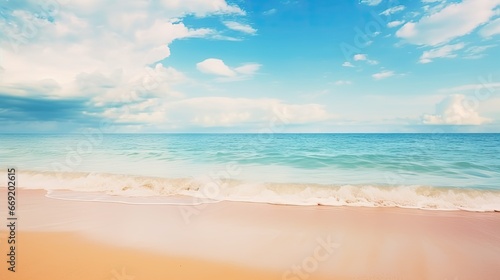Beautiful natural tropical summer beach background with golden sand, turquoise ocean, and blue sky with white clouds © Creative Canvas