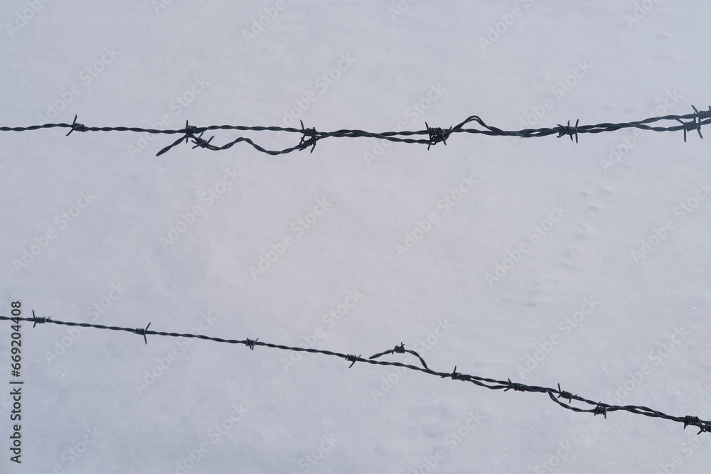 barbed wire, fence for cattle against background of beautiful white landscape, high mountains Swiss Alps, wide alpine winter road cleared, Winter Activity, travel by car barbed wire, fence for cattle against background of beautiful white landscape, high mountains Swiss Alps, wide alpine winter road cleared, Winter Activity, travel by car