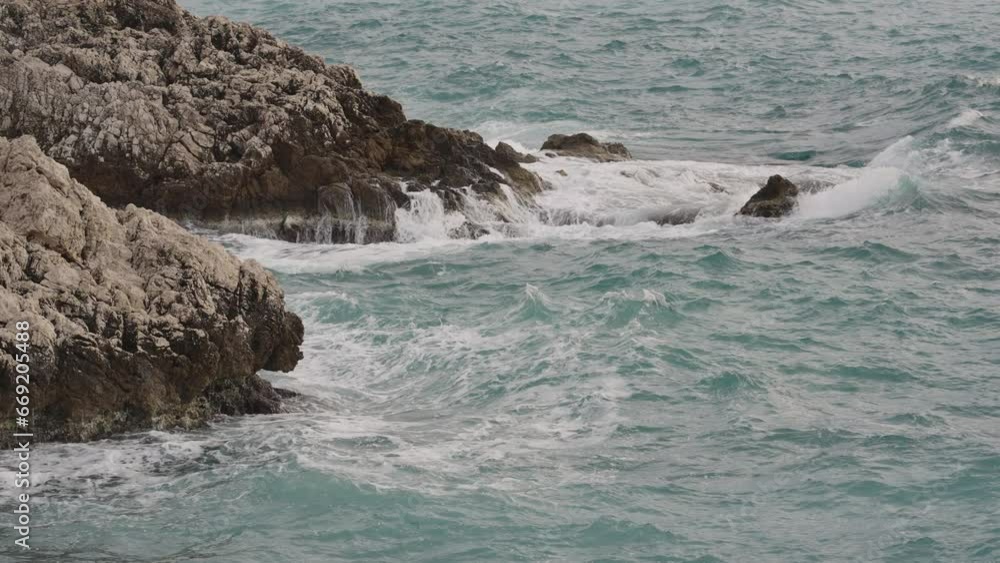 Slow motion sea waves crushing over rocks with soft light Slow motion sea waves crushing over rocks with soft light
