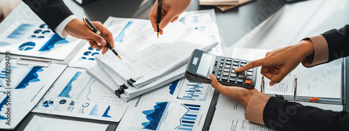 Auditor and accountant team working in office, analyze financial data and accounting record with calculator. Accounting company provide finance and taxation planning for profitable cash flow. Insight photo