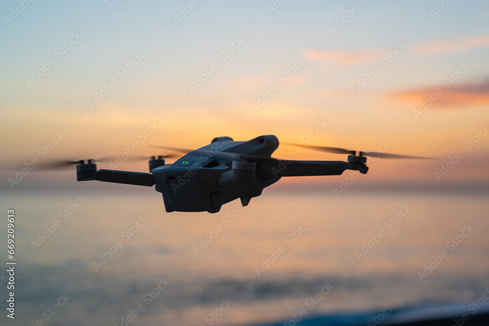 small drone flying against a magnificent sunset seascape. small drone flying against a magnificent sunset seascape.
