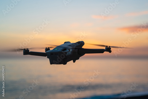 small drone flying against a magnificent sunset seascape. 