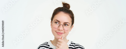 Portrait of pleased and thoughtful face, smiling satisifed, analizing smth, thinking, standing over white background photo