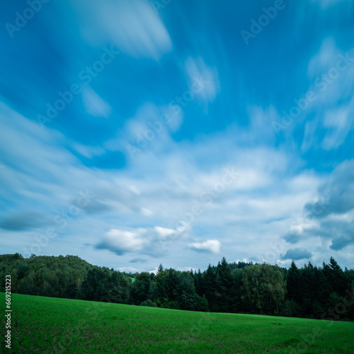 chmury w ruchu nad polem i lasem