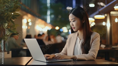Young asian business woman using digita tablet and working on laptop computer at modern office.  photo
