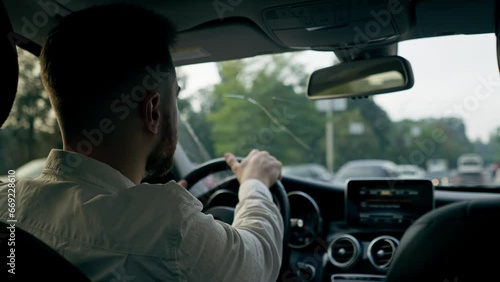 back view a man a businessman is driving a luxury car around the city a black leather interior a navigation screen traffic jams