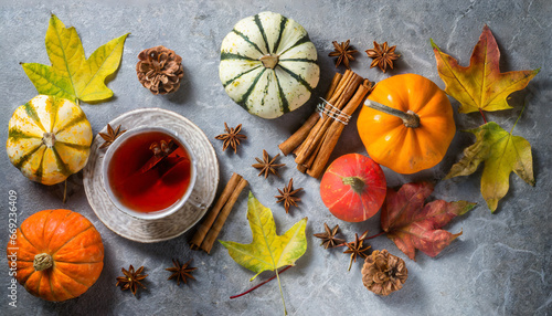 hot tea with fall foliage pumpkins cinnamon sticks and star anise colorful autumn leaves for happiness mood grey stone table top view