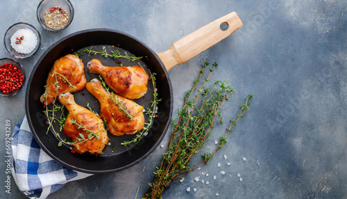 grilled chicken thighs in a frying pan with fresh thyme view from above flatlay empty space photo
