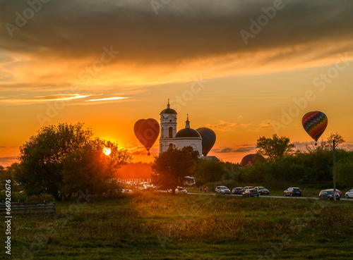 Evening village landscape with temple and balloons