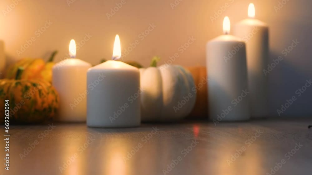 Thanksgiving and Hello Fall, celebrating autumn holidays at cozy home on the windowsill. Burning white candles and small pumpkins on the table. Thanksgiving and Hello Fall, celebrating autumn holidays at cozy home on the windowsill. Burning white candles and small pumpkins on the table.
