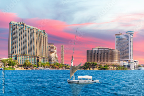 Nile river with fancy yacht and sunset sky over fashionable buildings of Cairo, Egypt