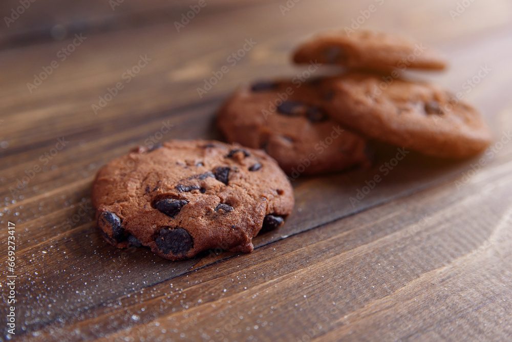 Fototapeta premium Shortbread cookies with chocolate chips on wooden background. Fresh pastry.