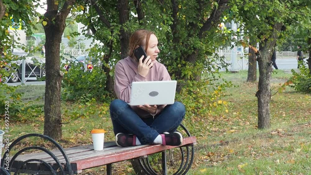 woman in the park on the bench with a laptop in her hands. Smiling freelancer working outdoors enjoying the good weather. Freelancing concept. Online education. communicates online on social networks woman in the park on the bench with a laptop in her hands. Smiling freelancer working outdoors enjoying the good weather. Freelancing concept. Online education. communicates online on social networks