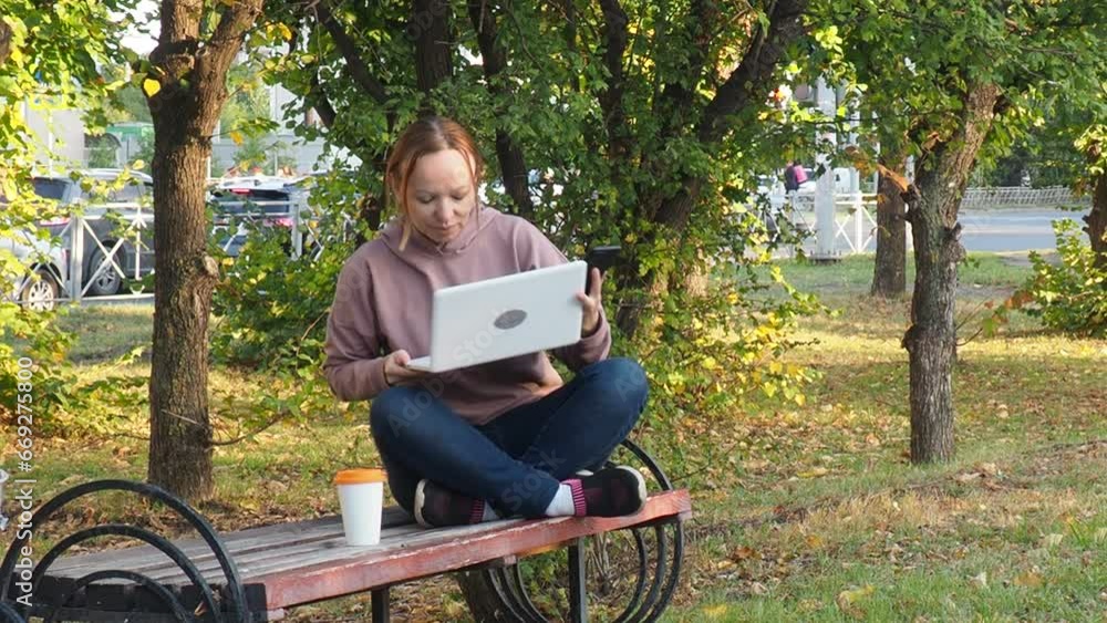 woman in the park on the bench with a laptop in her hands. Smiling freelancer working outdoors enjoying the good weather. Freelancing concept. Online education. communicates online on social networks woman in the park on the bench with a laptop in her hands. Smiling freelancer working outdoors enjoying the good weather. Freelancing concept. Online education. communicates online on social networks