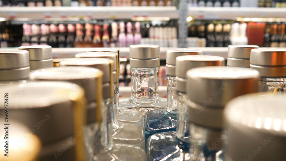 Close-up of many bottles of gin or vodka in alcohol department