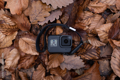Top view of a black actioncam placed on the leaves in the forest