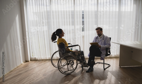 Portrait latin american woman sick sit wheelchair with man doctor caucasian sitting two people check and treat patients talk helping support explain medicine sick person inside hospital room service